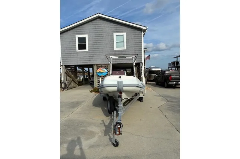 Slide: The Image of 2021 Highfield Sport 520 boat on trailer in front of a gray house. - 2