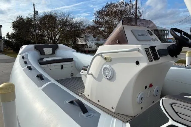 Slide: The Image of 2021 Highfield Sport 520 boat with modern console and seating, docked outdoors. - 6