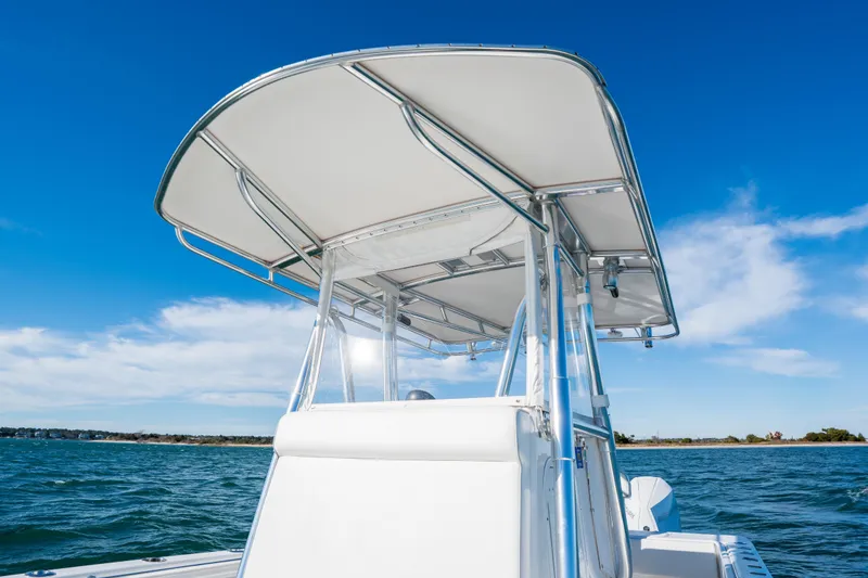 Slide: The Image of 2023 Contender 28 Sport boat with T-top on open water under clear blue sky. - 11