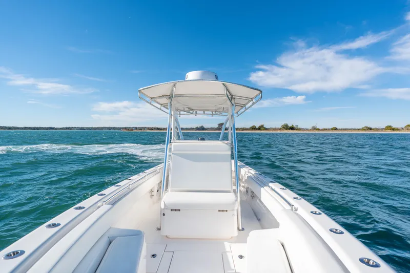 Slide: The Image of 2023 Contender 28 Sport boat cruising on open water under clear blue sky. - 8