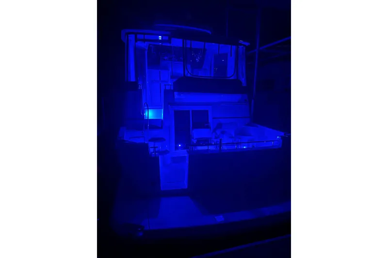 Slide: The Image of 2005 Carver 444 Cockpit Motor Yacht illuminated in blue light at night. - 13