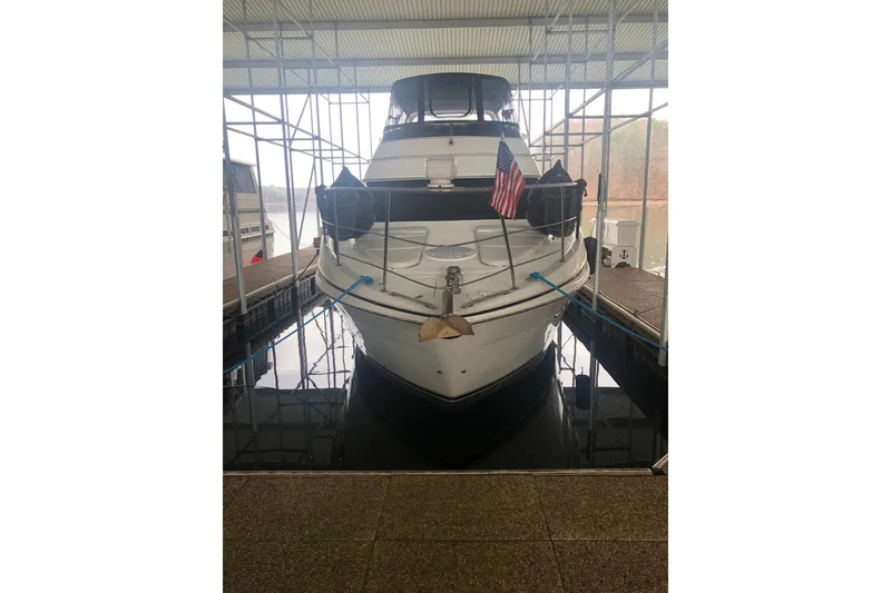 Slide: The Image of 2005 Carver 444 Cockpit Motor Yacht docked with American flag displayed. - 18