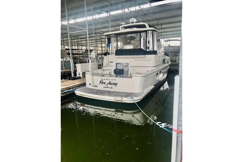 Slide: The Image of 2005 Carver 444 Cockpit Motor Yacht docked in a marina. - 20