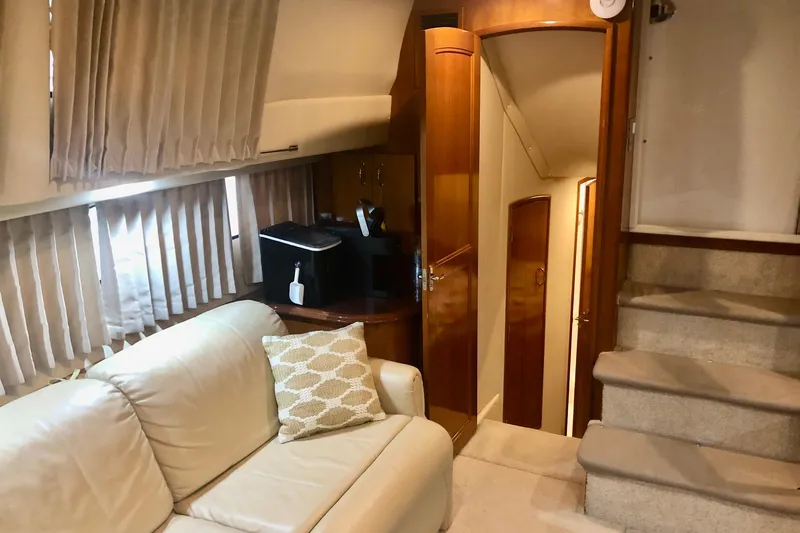 Slide: The Image of Interior of 2005 Carver 444 Cockpit Motor Yacht with beige sofa and wooden cabinetry. - 52