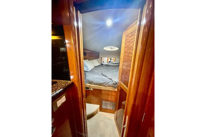 Slide: The Image of 2005 Carver 444 Cockpit Motor Yacht interior cabin with cozy bed and wooden finish. - 59