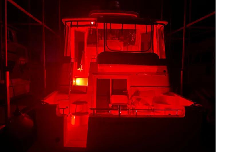Slide: The Image of 2005 Carver 444 Cockpit Motor Yacht illuminated in red light at night. - 11