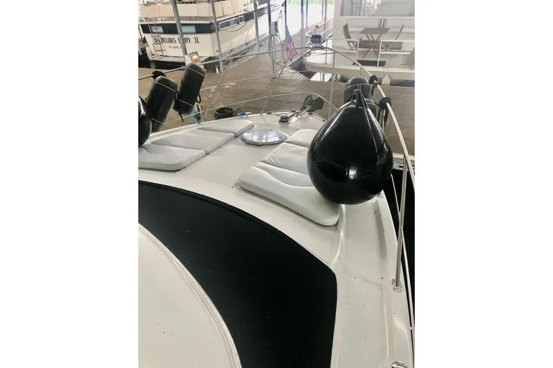 Slide: The Image of 2005 Carver 444 Cockpit Motor Yacht with deck cushions and fenders in marina. - 30
