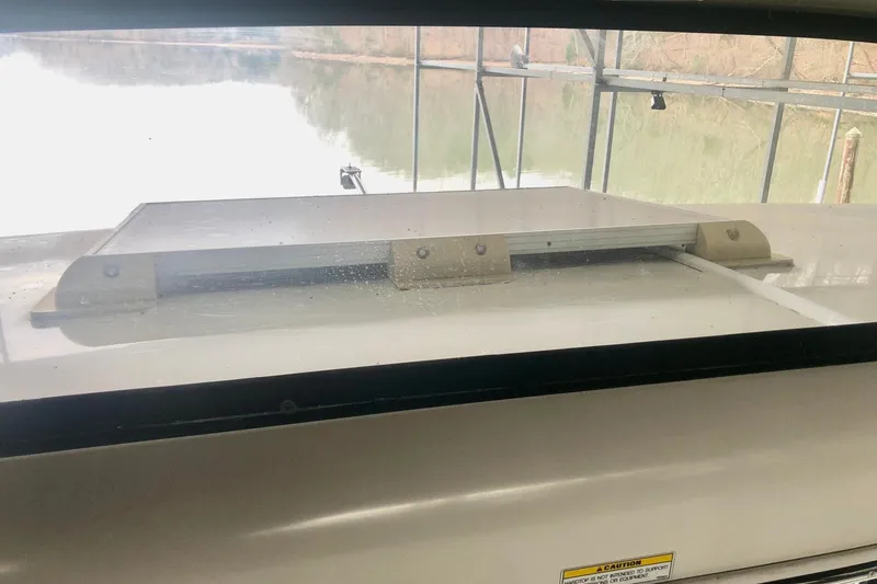 Slide: The Image of 2005 Carver 444 Cockpit Motor Yacht window view with water and dock background. - 47