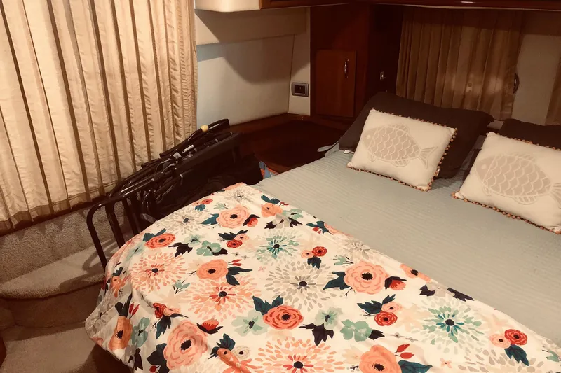 Slide: The Image of 2005 Carver 444 Cockpit Motor Yacht bedroom with floral bedding and decorative pillows. - 67