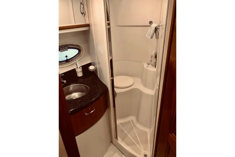 Slide: The Image of 2005 Carver 444 Cockpit Motor Yacht bathroom with sink, shower, and porthole window. - 71