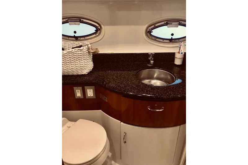 Slide: The Image of 2005 Carver 444 Cockpit Motor Yacht bathroom with sink, countertop, and porthole window. - 72