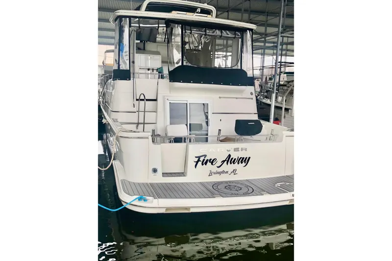 Slide: The Image of 2005 Carver 444 Cockpit Motor Yacht docked, rear view with "Fire Away" name. - 8