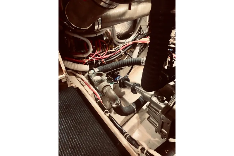 Slide: The Image of Engine room of 2005 Carver 444 Cockpit Motor Yacht with visible pipes and wiring. - 82
