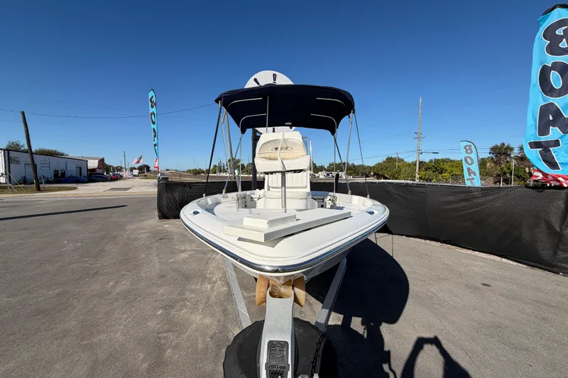 Slide: The Image of 2013 Sea Hunt XP 19 boat on trailer, displayed outdoors under clear blue sky. - 12