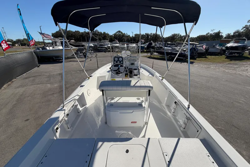 Slide: The Image of 2013 Sea Hunt XP 19 boat with canopy, parked in a marina lot. - 14