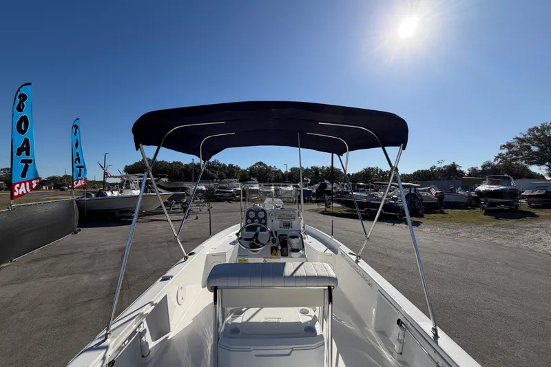 Slide: The Image of 2013 Sea Hunt XP 19 boat with canopy at a sale event under sunny sky. - 15