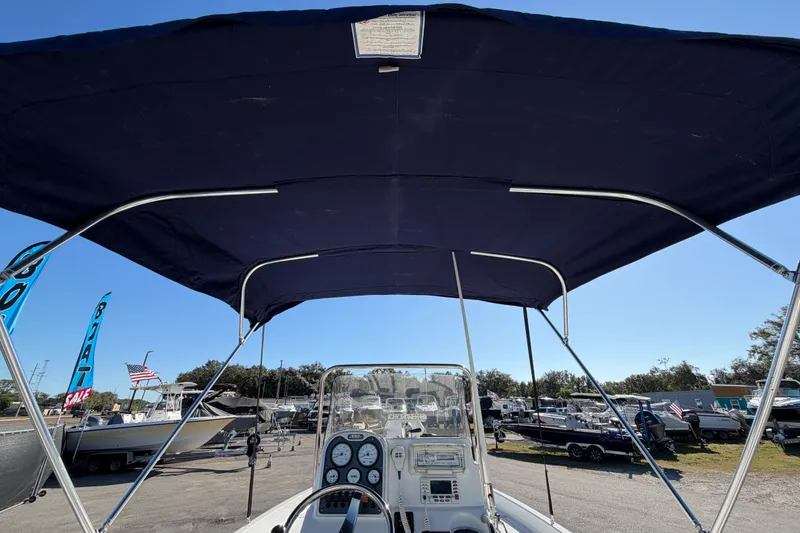 Slide: The Image of 2013 Sea Hunt XP 19 boat with canopy, dashboard view, parked in marina. - 20