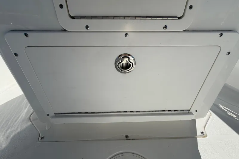 Slide: The Image of 2013 Sea Hunt XP 19 boat storage compartment with metal latch, white finish. - 27