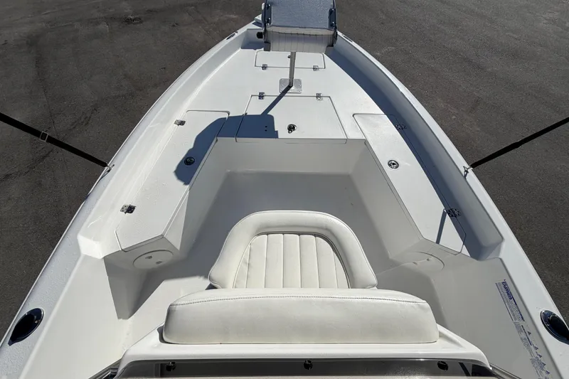 Slide: The Image of 2013 Sea Hunt XP 19 boat interior with white seating and storage compartments. - 30