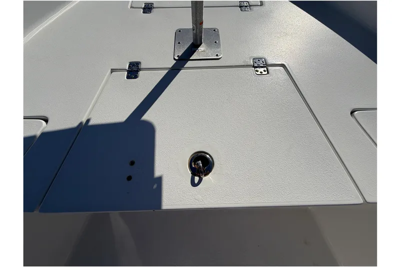 Slide: The Image of 2013 Sea Hunt XP 19 boat deck with storage compartments and metal fixtures. - 35