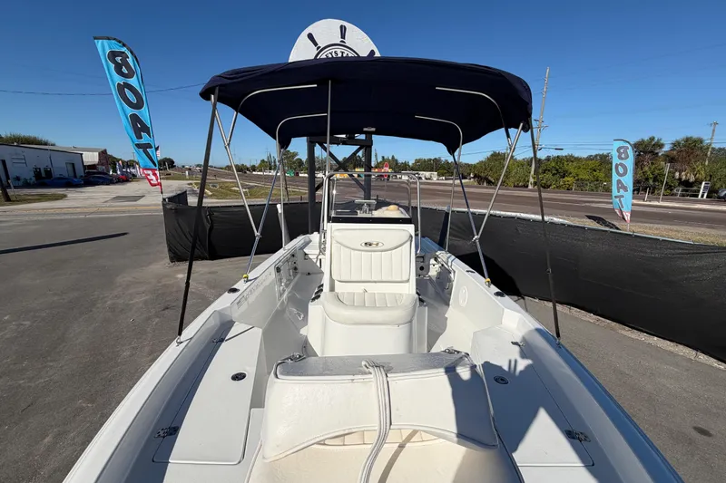 Slide: The Image of 2013 Sea Hunt XP 19 boat with canopy, parked on a sunny day. - 43