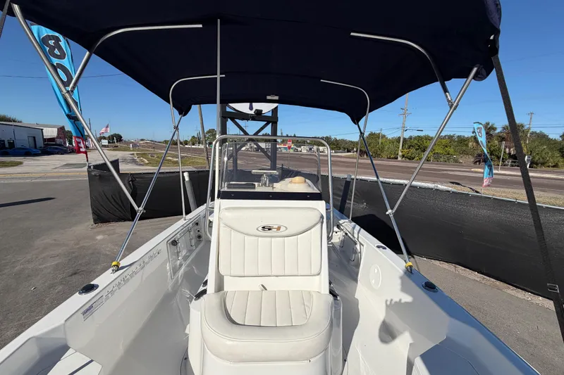 Slide: The Image of 2013 Sea Hunt XP 19 boat with canopy, parked on a sunny day. - 49