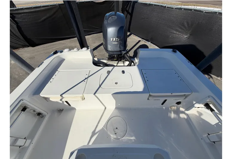 Slide: The Image of 2013 Sea Hunt XP 19 boat interior with Yamaha 115 engine, featuring storage compartments. - 54