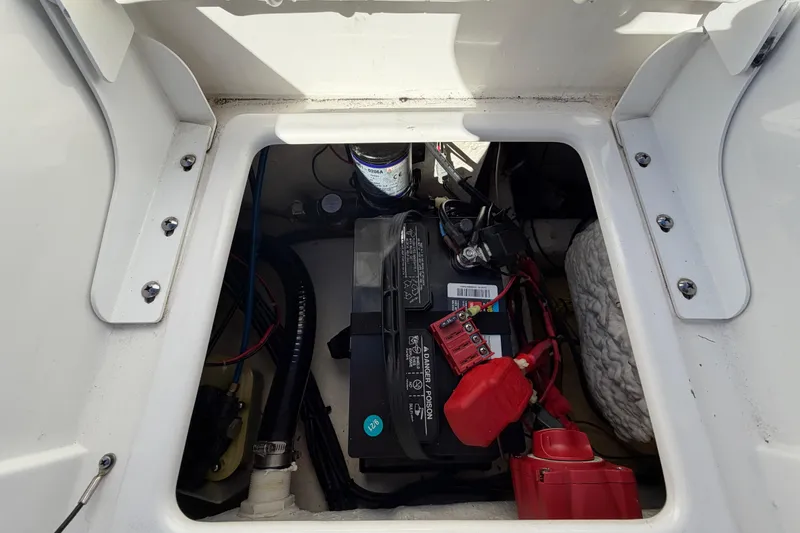 Slide: The Image of Battery compartment of a 2013 Sea Hunt XP 19 boat, showing wiring and components. - 57