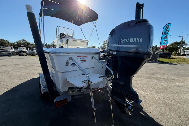 Slide: The Image of 2013 Sea Hunt XP 19 boat with Yamaha outboard motor in a sunny dealership lot. - 7