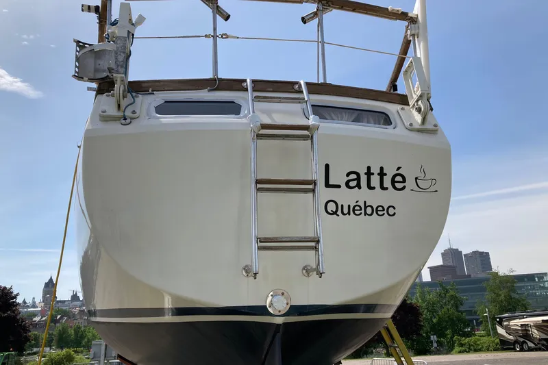 Slide: The Image of 1987 Nauticat 38 sailboat named "Latté Québec" with cityscape background. - 11