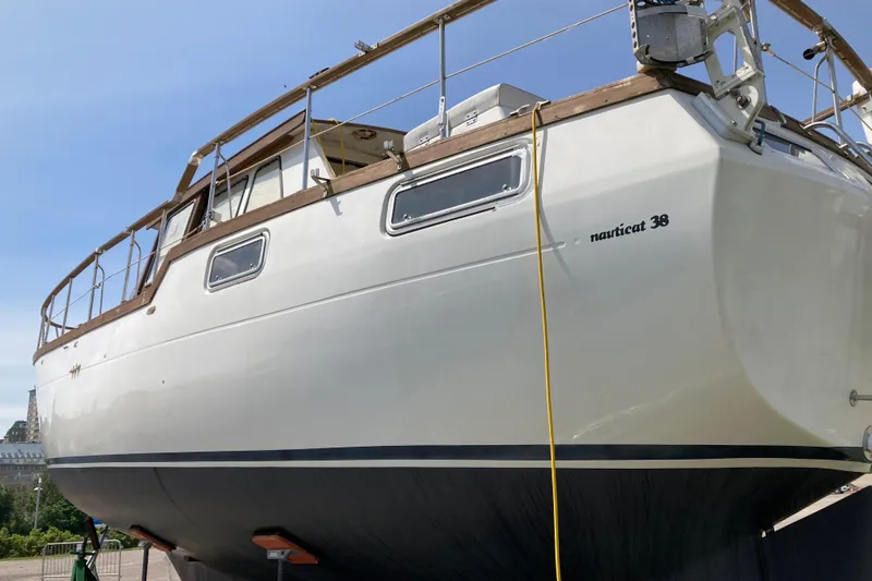 Slide: The Image of 1987 Nauticat 38 sailboat on dry dock, showcasing its sleek design and sturdy build. - 12