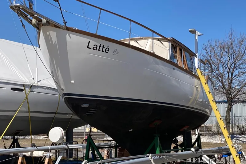 Slide: The Image of 1987 Nauticat 38 sailboat named "Latté" on dry dock with clear blue sky. - 13