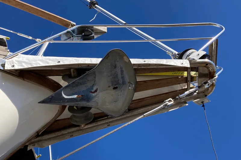 Slide: The Image of 1987 Nauticat 38 sailboat bow with anchor against clear blue sky. - 19