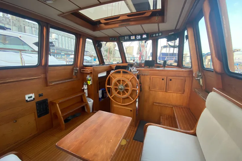 Slide: The Image of Interior of 1987 Nauticat 38 sailboat with wooden helm and seating area. - 26