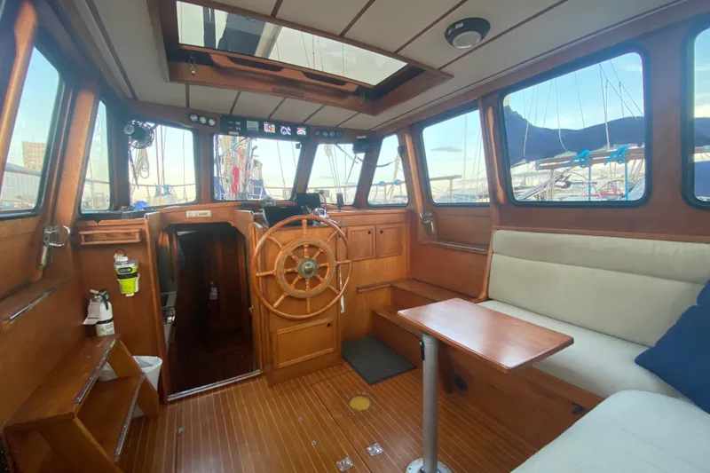 Slide: The Image of Interior of 1987 Nauticat 38 sailboat with wooden helm and seating area. - 27