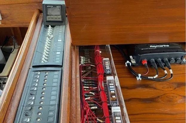 Slide: The Image of Electrical panel and wiring inside a 1987 Nauticat 38 sailboat, featuring Raymarine equipment. - 32