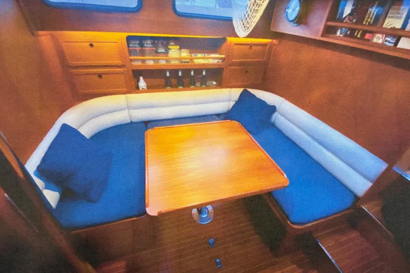 Slide: The Image of Cozy interior of 1987 Nauticat 38 sailboat with wooden table and cushioned seating. - 36