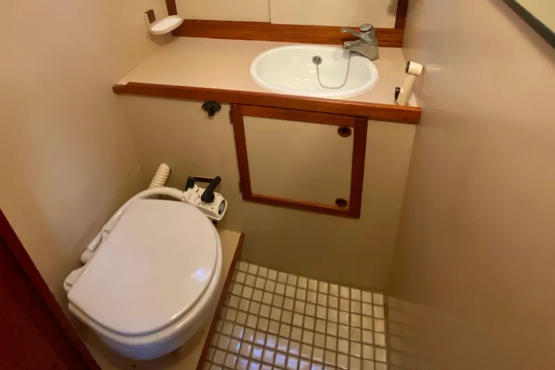 Slide: The Image of Compact bathroom in a 1987 Nauticat 38 sailboat, featuring a toilet and sink. - 40
