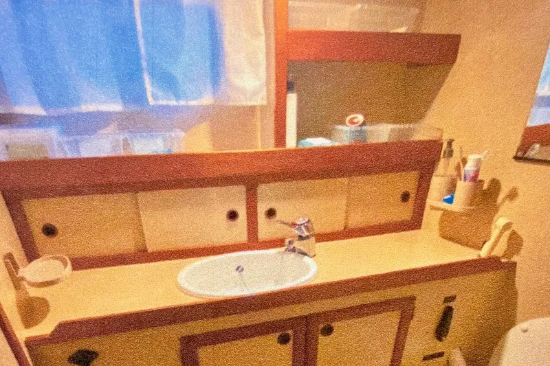 Slide: The Image of 1987 Nauticat 38 yacht bathroom with sink, mirror, and storage cabinets. - 45