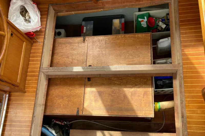 Slide: The Image of Interior storage area of 1987 Nauticat 38 sailboat with wooden cabinetry and various items. - 47