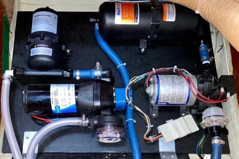 Slide: The Image of Boat water pump system in a 1987 Nauticat 38, featuring hoses and electrical connections. - 55