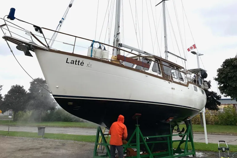 Slide: The Image of 1987 Nauticat 38 sailboat "Latté" on dry dock, Canadian flag, person in orange jacket. - 6