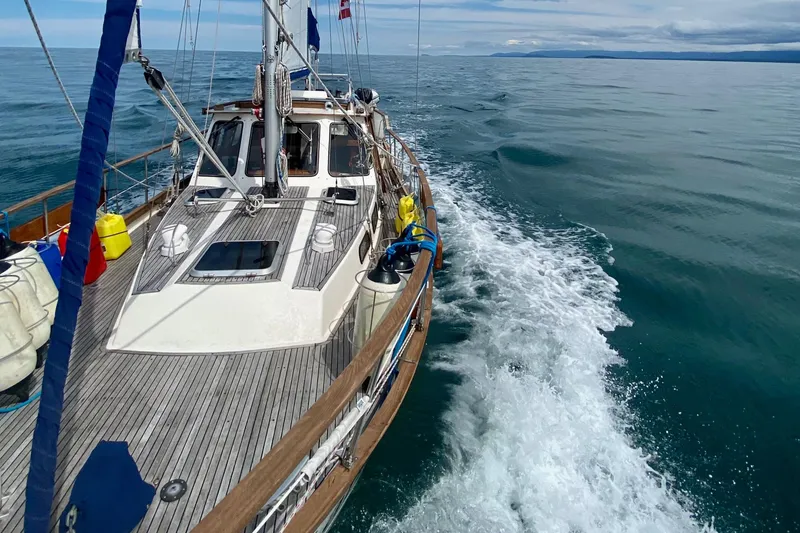 Slide: The Image of Sailing on a 1987 Nauticat 38 yacht, cruising through calm ocean waters. - 63