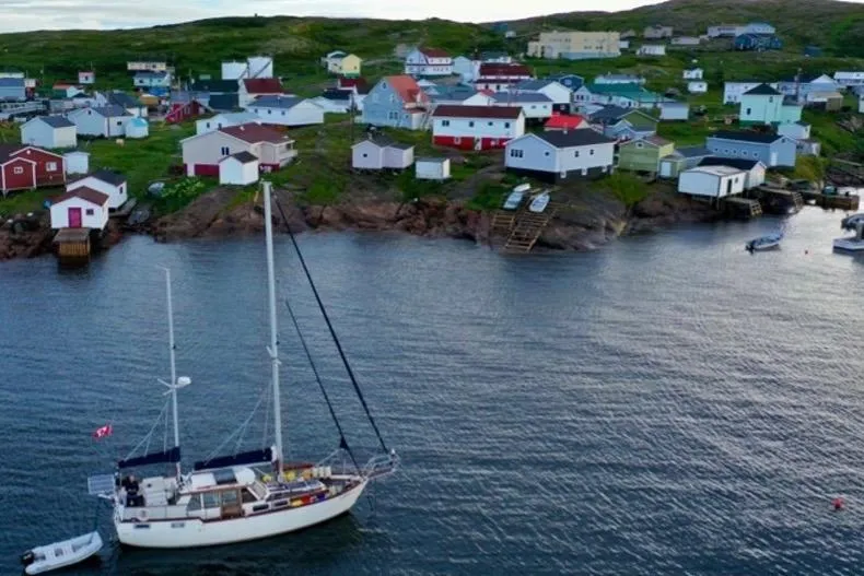 Slide: The Image of Sailboat Nauticat 38 (1987) anchored near colorful coastal village houses. - 65