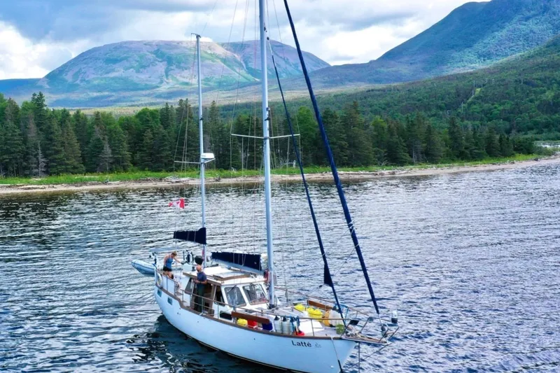 Slide: The Image of Sailboat Nauticat 38 (1987) on scenic lake with forested mountains in background. - 67