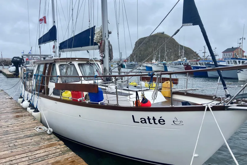 Slide: The Image of 1987 Nauticat 38 sailboat "Latté" docked in a marina on a cloudy day. - 68