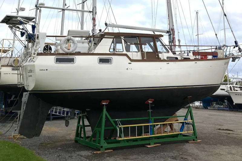Slide: The Image of 1987 Nauticat 38 sailboat on dry dock, showcasing its sturdy hull and classic design. - 8