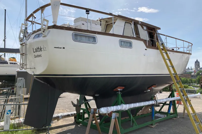 Slide: The Image of 1987 Nauticat 38 sailboat on dry dock with ladder, labeled "Latte Québec." - 9