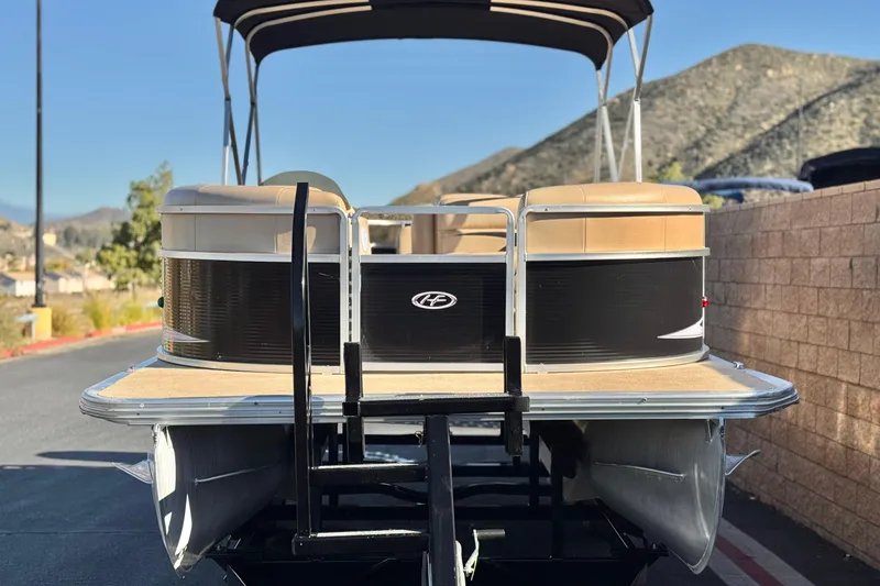 Slide: The Image of 2011 Harris Cruiser 220 CX pontoon boat on trailer, scenic mountain backdrop. - 2