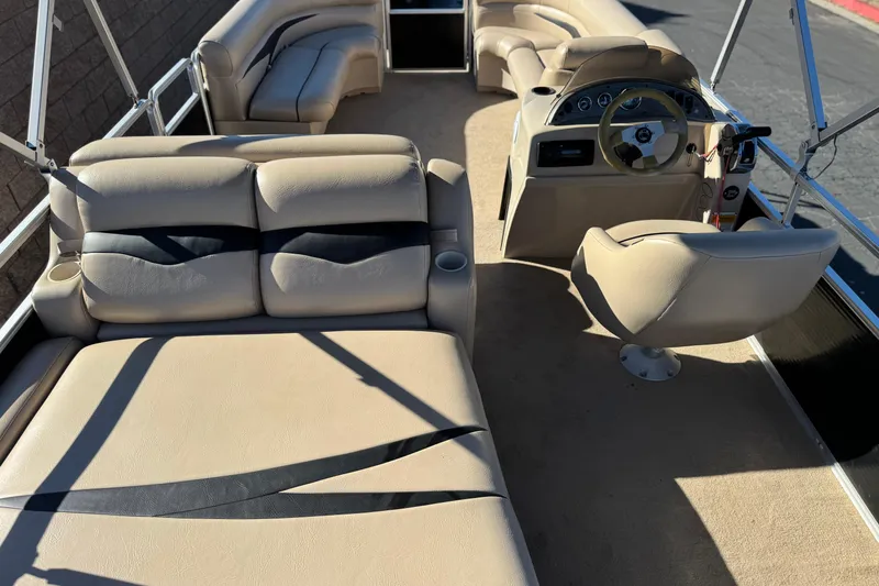 Slide: The Image of 2011 Harris Cruiser 220 CX pontoon boat interior with beige seating and steering console. - 20